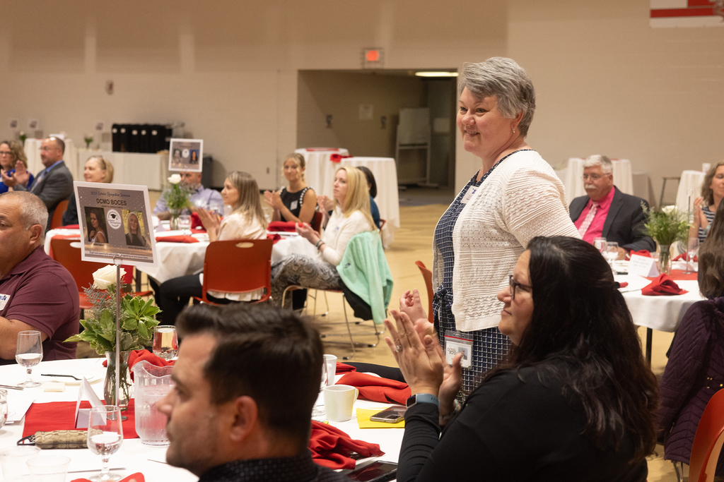 woman standing among seated guests