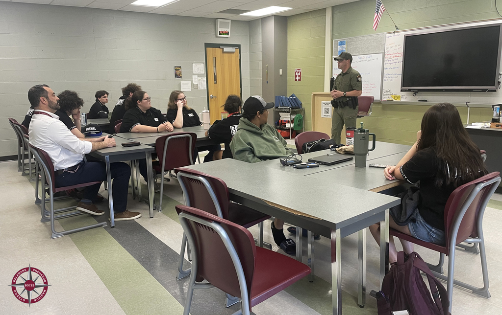 NYS Forest Ranger speaks to a group of students and an assistant principal in the classroom