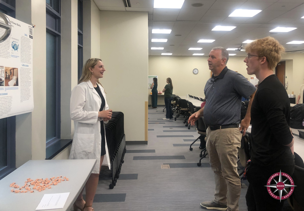 student speaking to adults after presentation