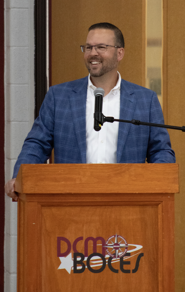 superintendent smiles at lectern