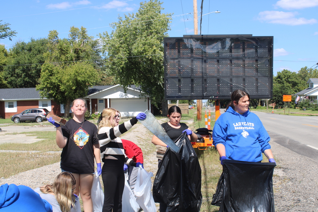 girl group picking up trash