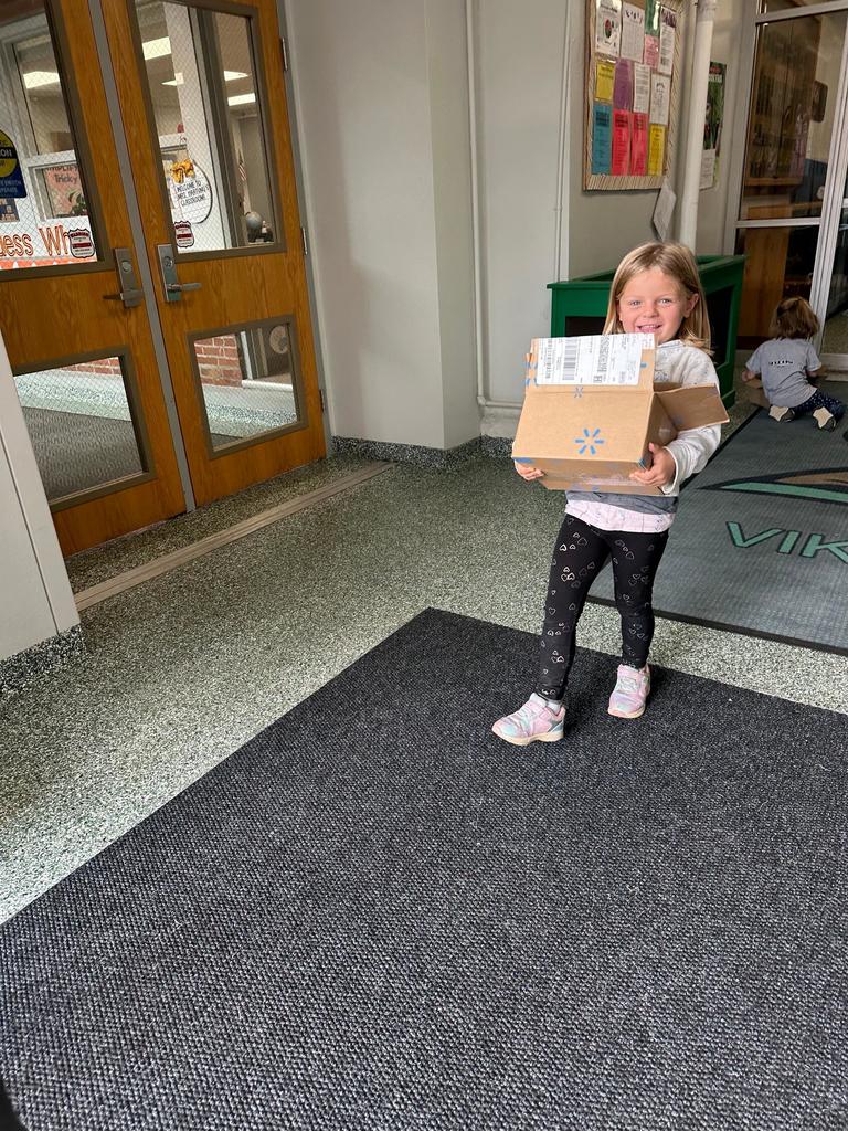 small girl holding a box smiling