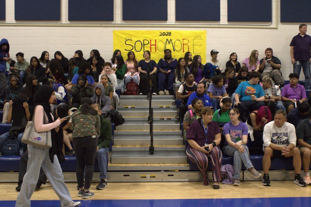 NEC students sitting on the bleachers in the gym