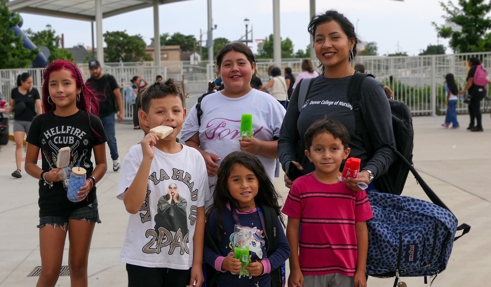 A family poses for a photo while eating a sweet treat at Back to School Night.