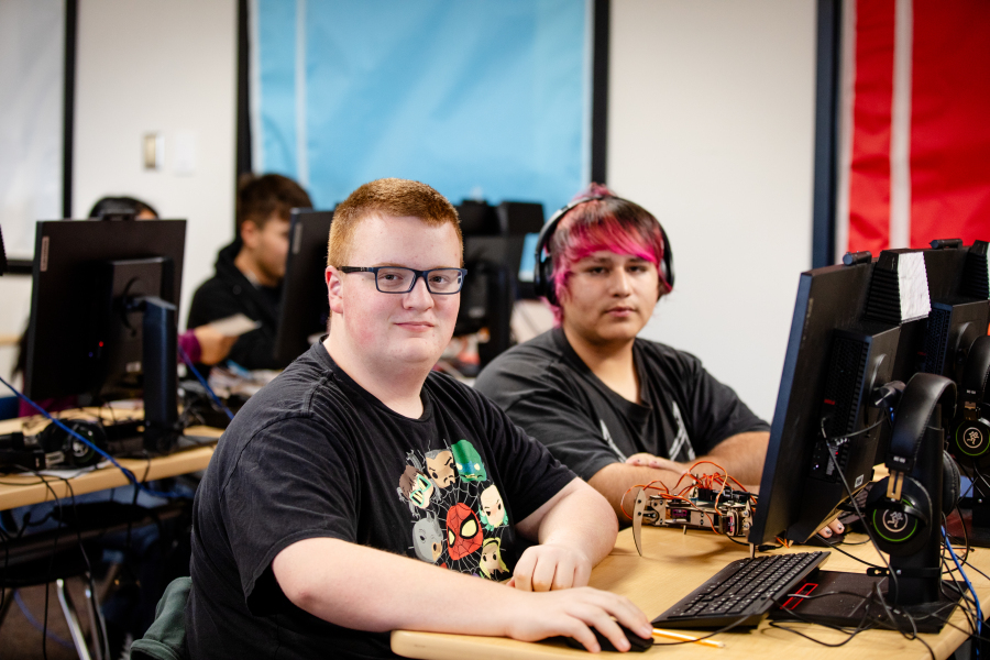 Students smile while working at their desks