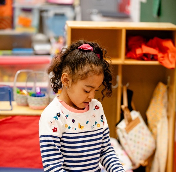 Student playing with a baby doll in class