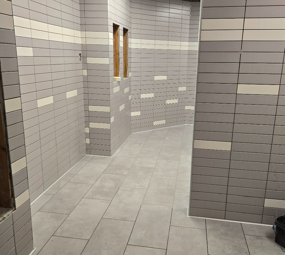 Entrance to newly remodeled bathroom with fresh tiles and floors