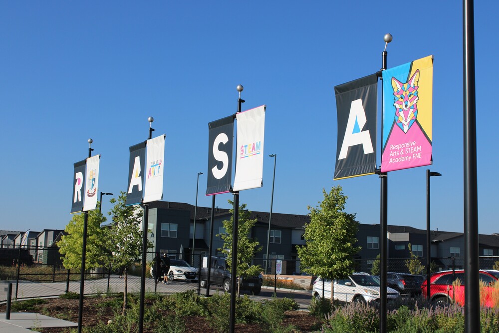 Banners with the letters R A S A on flagpoles in the school parking lot
