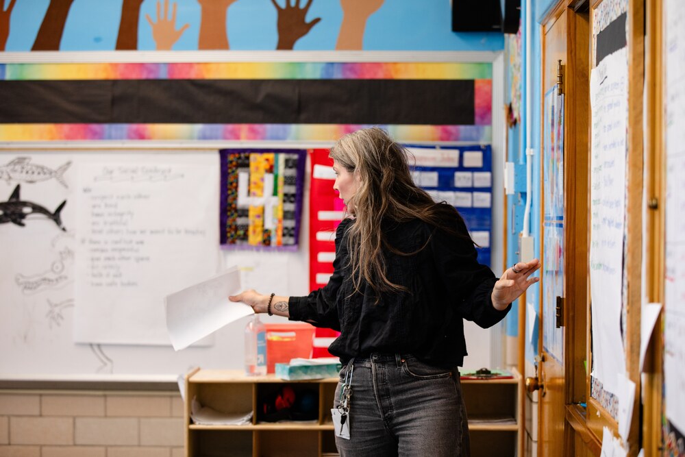 a female teacher in a black shirt lectures in a classroom at Hallett Academy