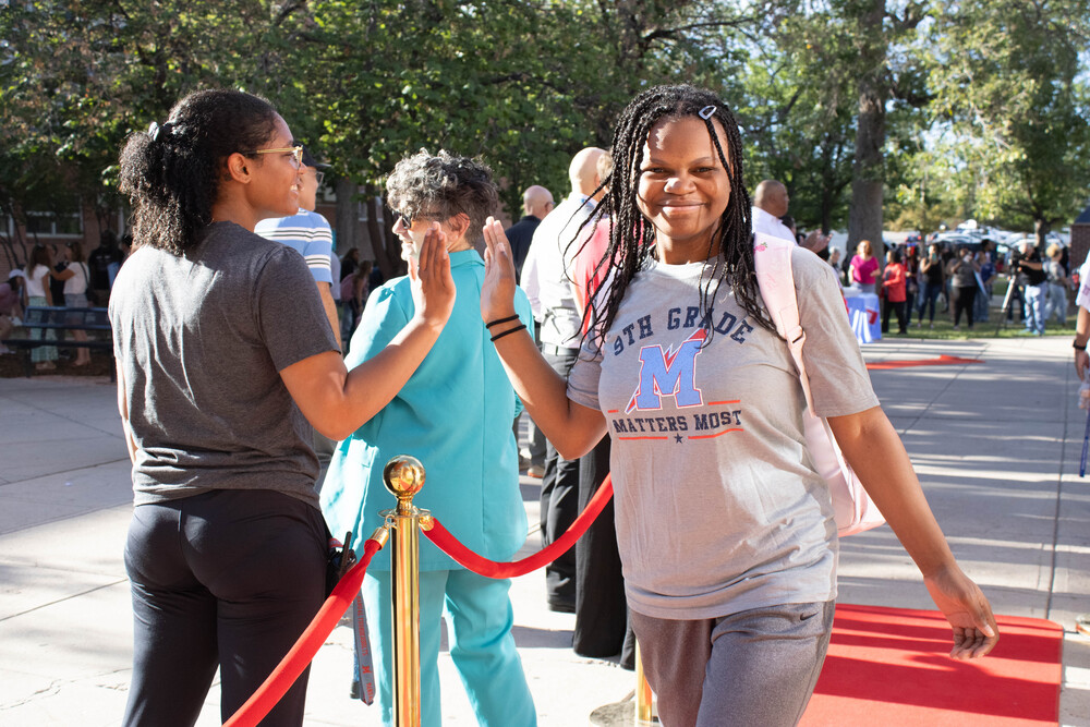 Manual student high fives Manual staff on first day of school