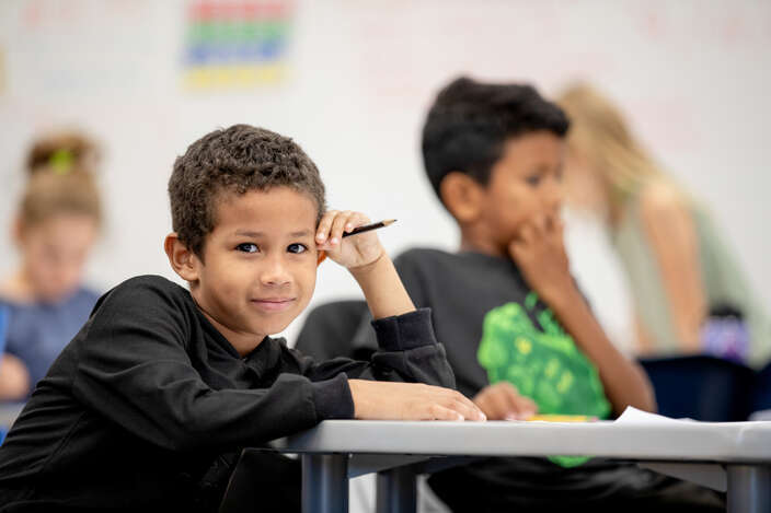 Elementary student sitting at desk facing the camera