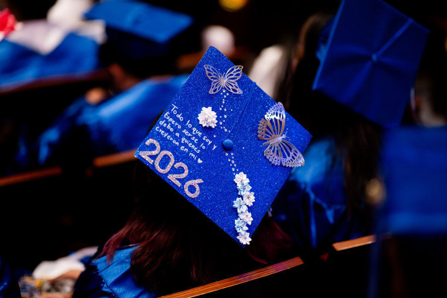 Decorated cap at graduation with butterflies, flowers and a phrase in Spanish