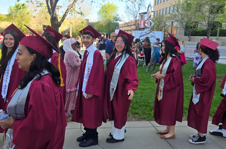 Graduates walking on the lawn in their caps and gowns