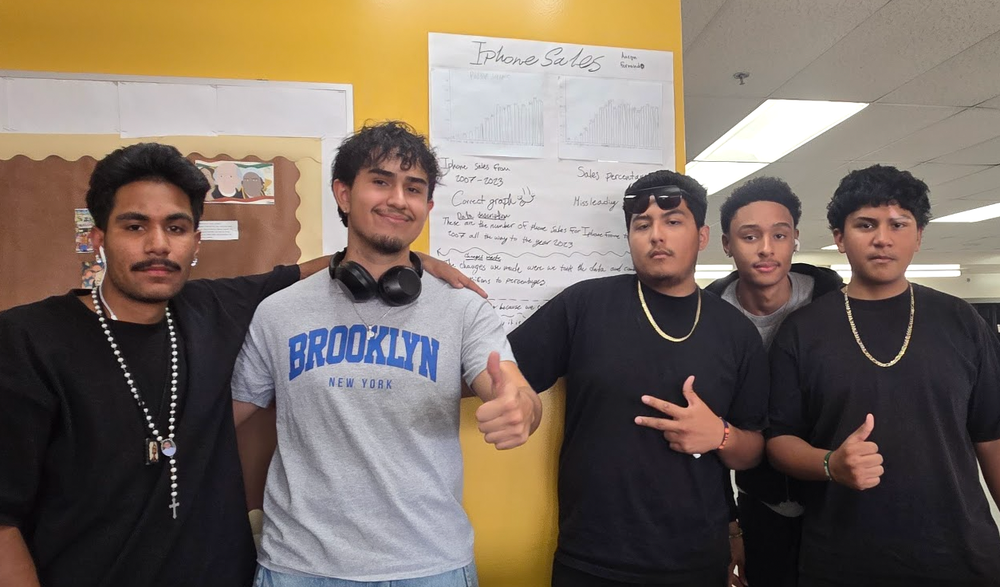 5 students smiling at the camera holding up peace signs