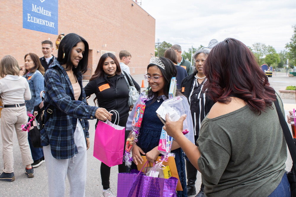 McMeen student smiles while she receives gifts from her family after graduation