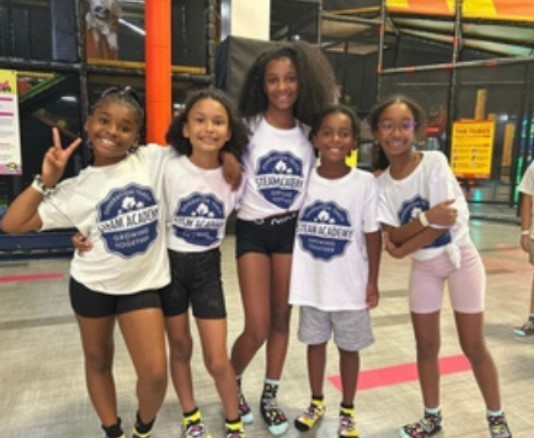 a group of 5 students smiling with their  together as a group