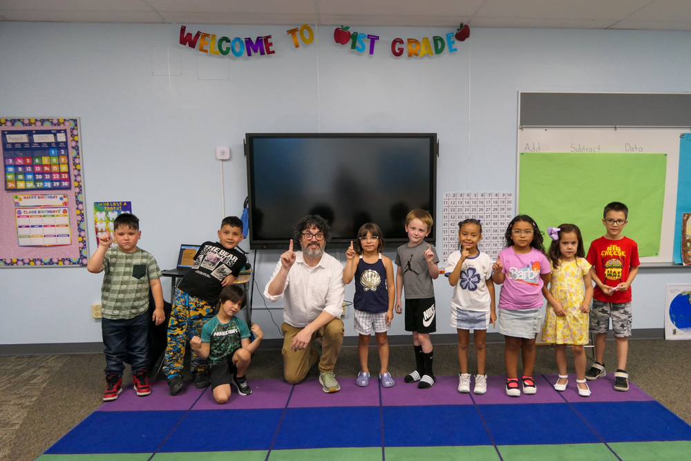 Mr. Rucker poses for a photo with his first grade class.