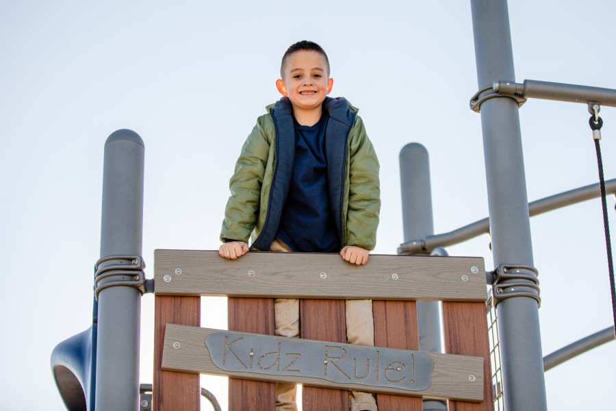 A student poses for a photo on the playground.