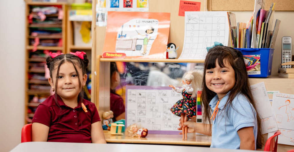 two students playing and smiling in class