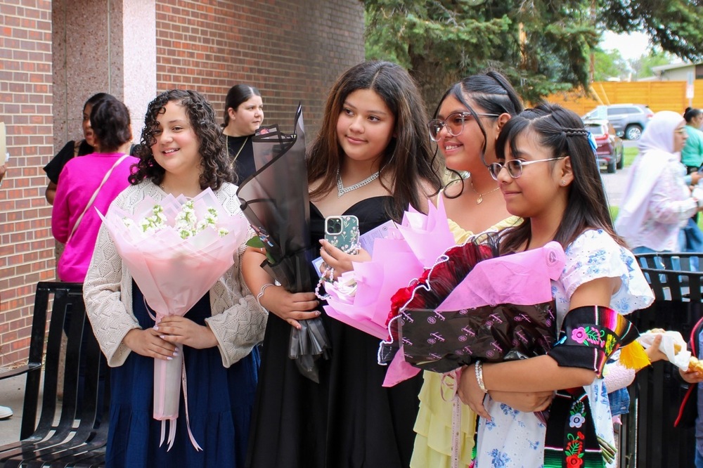 Graduating students holding bouquets