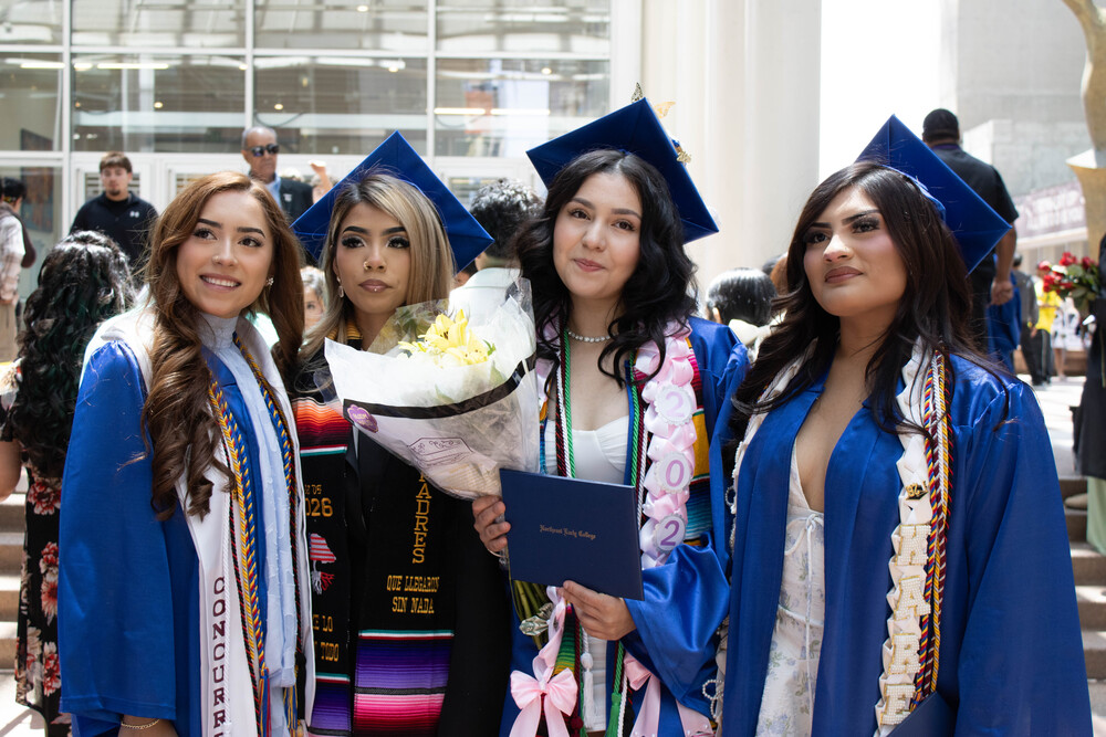 4 students smile in their caps and gowns