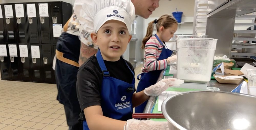 Student with a chef hat looking at the camera
