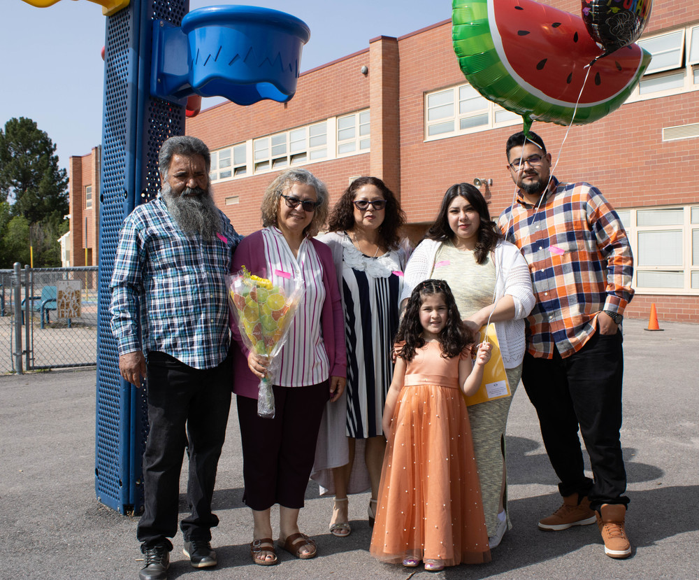 McMeen student holds up balloons with her family as she celebrates graduation
