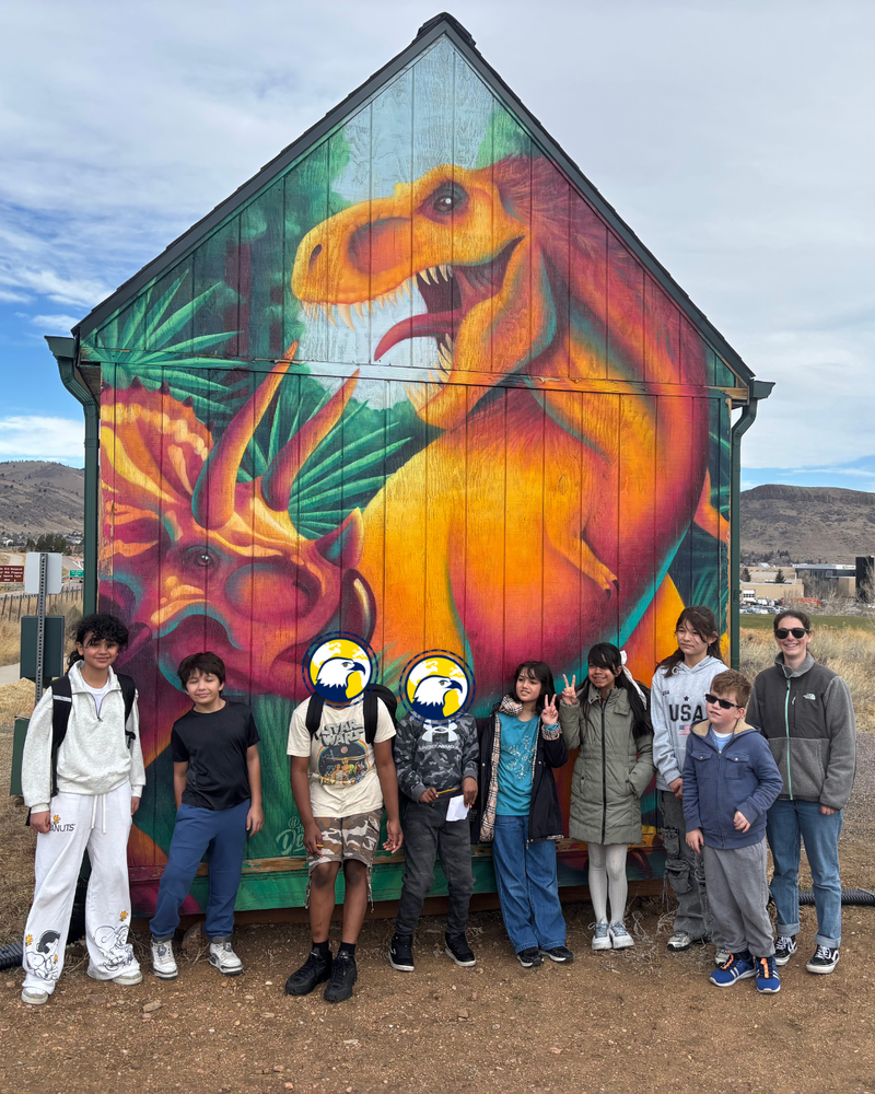 Students in front of painted dinosaur mural