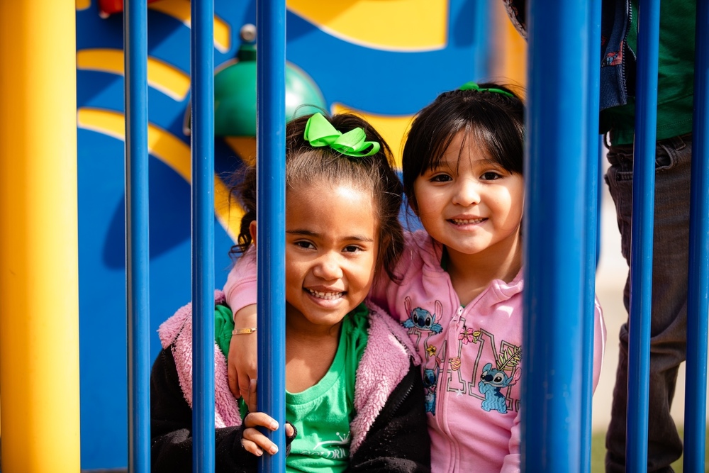 two students hugging and smiling on a jungle gym