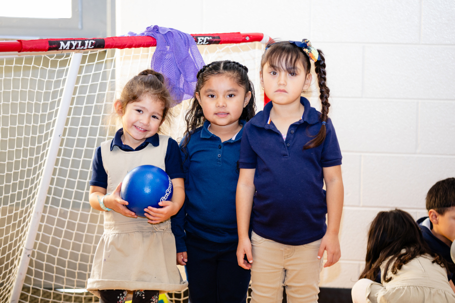 Three students pose for a photo in gym class. 