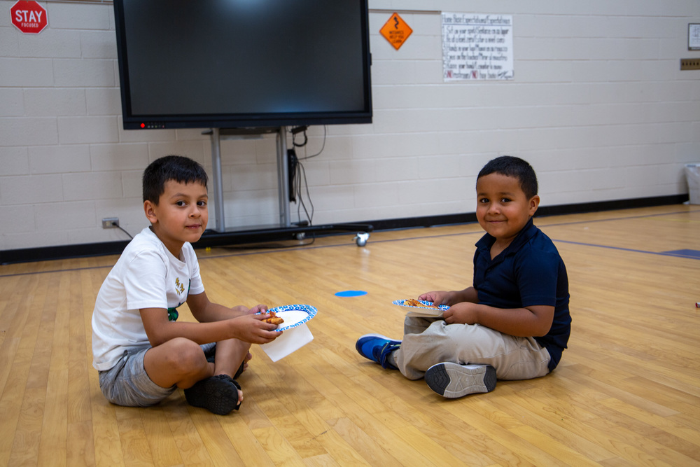 Two Swansea students pose for a photo at K-3 Literacy night after eating pizza.