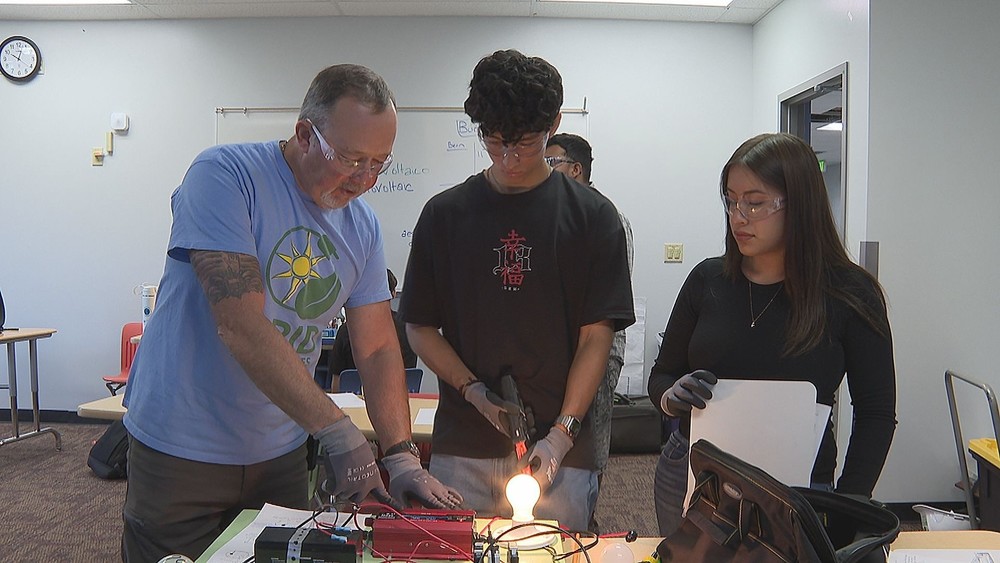 Students and teacher working on electrical circuit