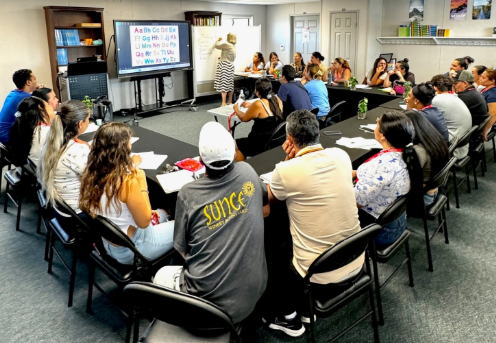 A group of adults listening to a speaker present.