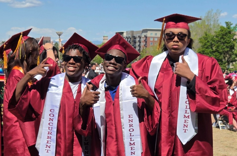 Students smile with thumbs up at graduation