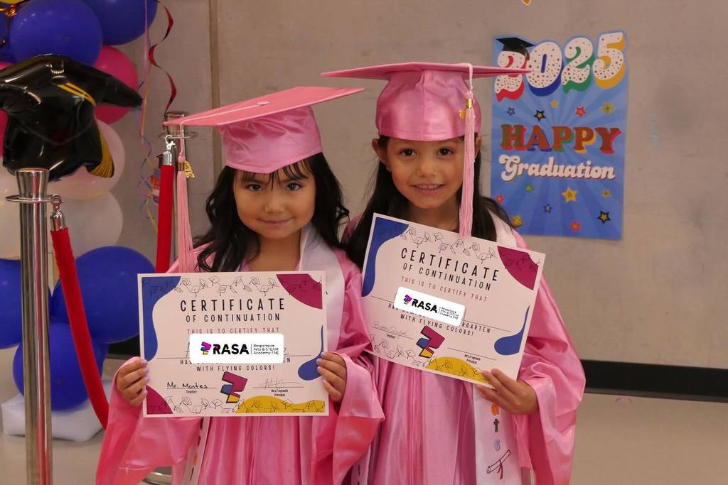 two students holding certificates of continuation wearing graduation cap and gown