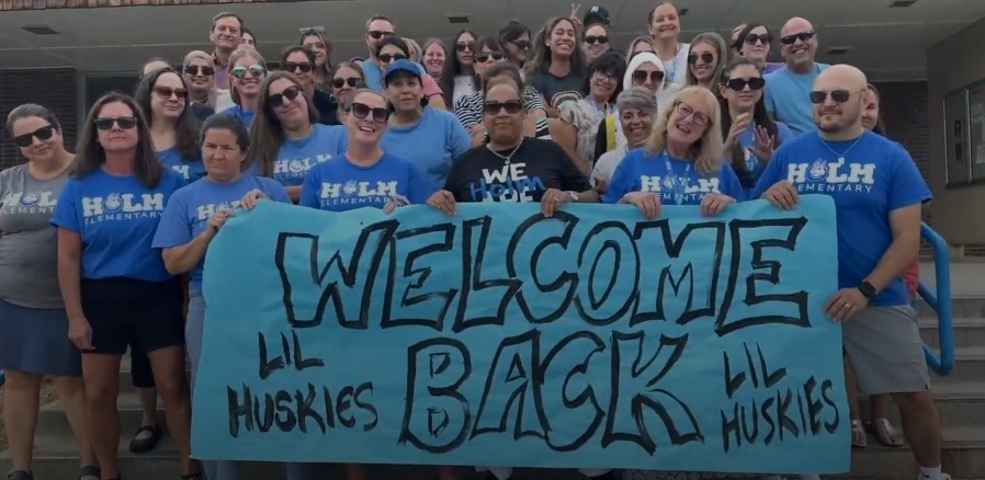 Holm staff holding a sign