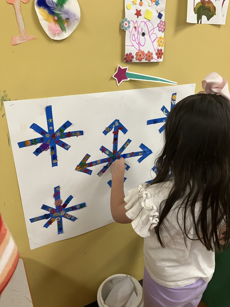 student collage sequins on a group snowflake project
