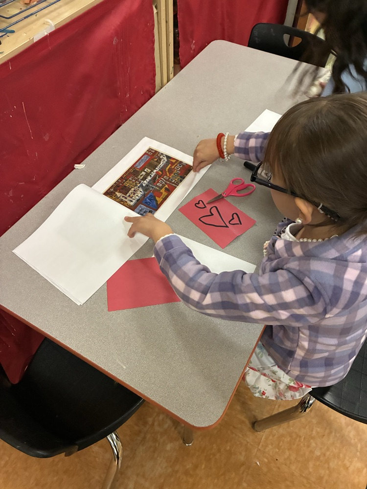 a student referencing a booklet of Black art in the multi media center