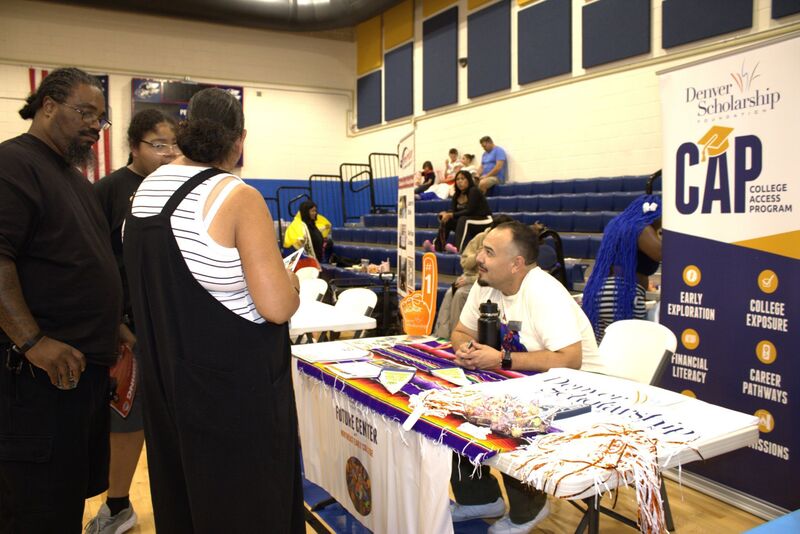 families stop at a table to talk to the Denver Scholarship Foundation