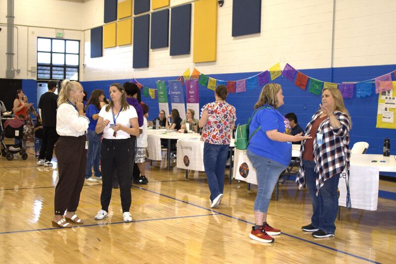Families walk around the decorated gym