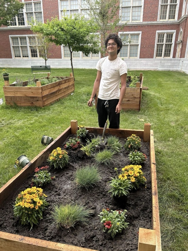 Student standing in front of garden