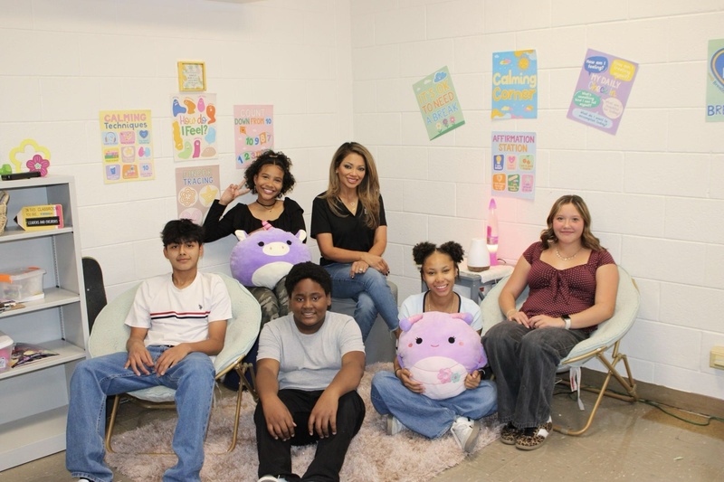 Liza sitting with students in office