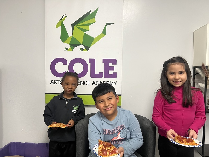 three students eating pizza