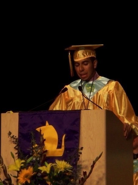 Dr. Solano in a cap and gown at a podium