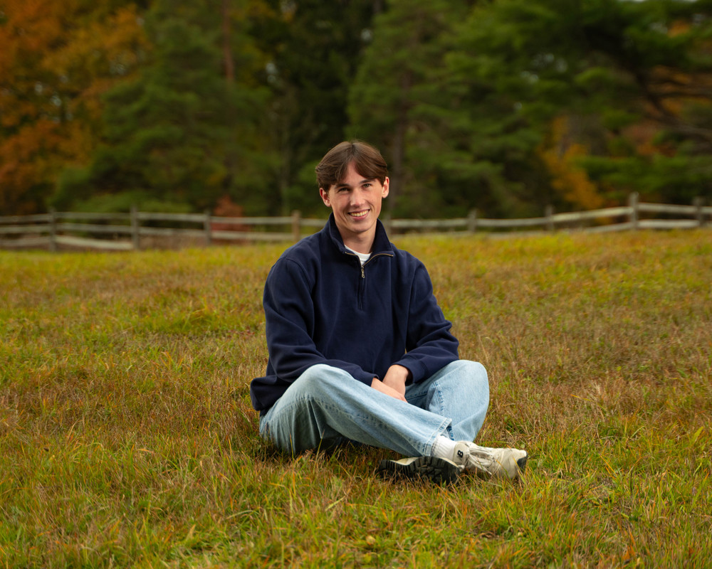 andrew peszko sitting in a field