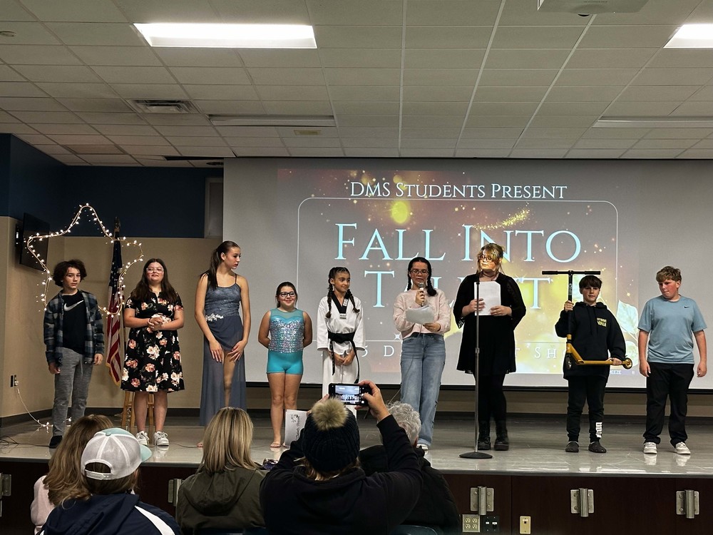 Students stand on stage at talent show