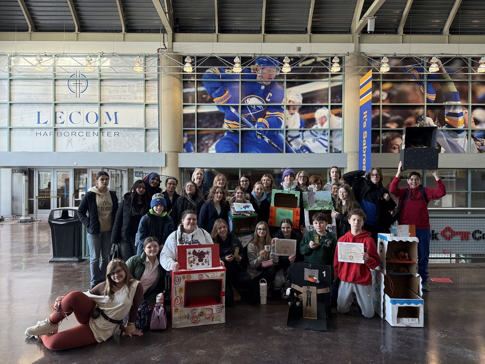 Students pose for a photo with cardboard arcade projects.