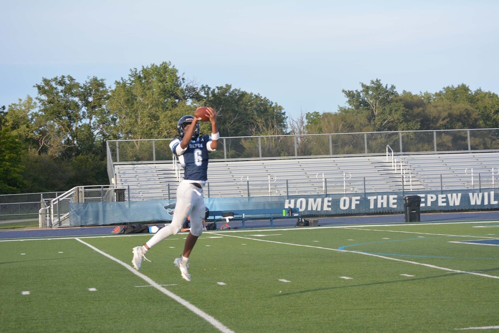 football player catching football in the air