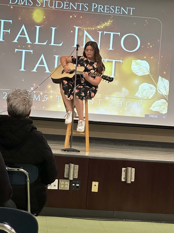 Students stand on stage at talent show