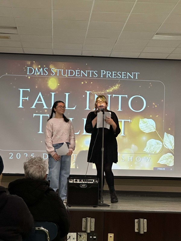 Students stand on stage at talent show